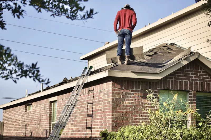Professional roofer working on a residential roof in Kellogg School